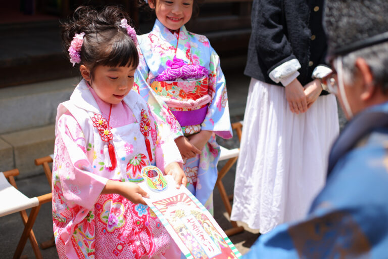 ご祈祷後に授与品を受け取る女の子